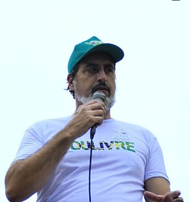 Cláudio Luís Caivano discursa ao microfone em ato público pela liberdade e pela anistia